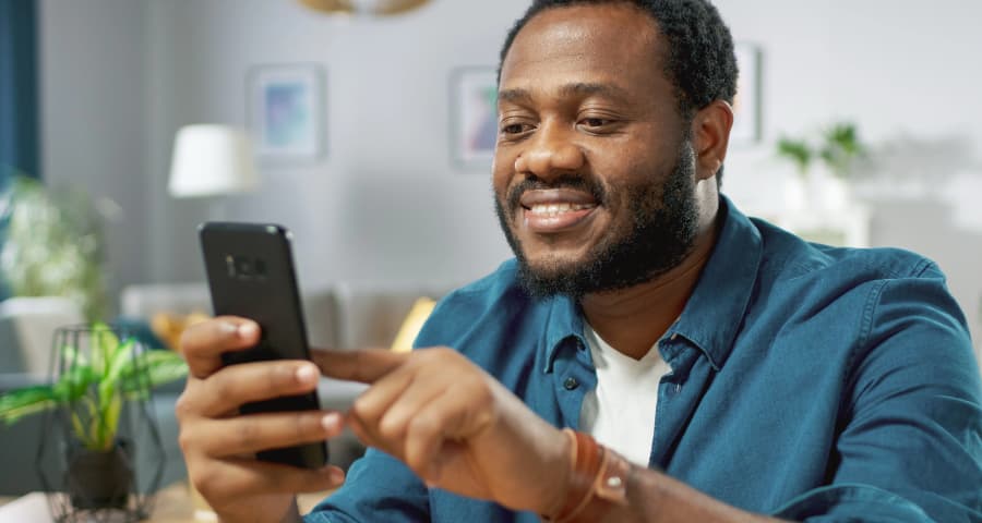 Man at home using a home security app on his phone